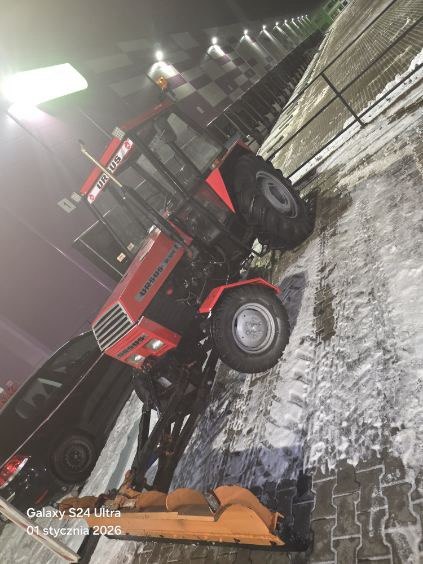 Ciągnik z pługiem podczas zimowych prac